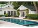 Backyard pool area featuring a pool with dark blue trim, adjacent buildings, and lush greenery and garden areas at 1011 Lake Davis Dr, Orlando, FL 32806