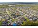 Aerial view of a neighborhood with lush landscaping, and a lake in the distance at 10640 Tibbett St, Orlando, FL 32832