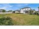 Large backyard with lush green grass, a white fence, and a covered patio with outdoor furniture at 10640 Tibbett St, Orlando, FL 32832