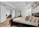 Bright bedroom with a large bed, hardwood floors, tray ceiling, and access to the staircase and second story at 10640 Tibbett St, Orlando, FL 32832