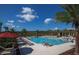 Beautiful community pool with lounge chairs, palm trees, and an umbrella covered picnic area at 10640 Tibbett St, Orlando, FL 32832