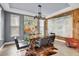 Modern dining room with glass table, leather chairs, gray walls, wood accent wall, and unique artwork at 10640 Tibbett St, Orlando, FL 32832