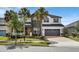 Beautiful two-story home with gray and white exterior, yellow door, attached garage, and well-maintained landscaping at 10640 Tibbett St, Orlando, FL 32832