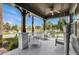 Cozy front porch features stone columns, white railings, comfortable seating, and a ceiling fan at 10640 Tibbett St, Orlando, FL 32832