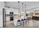 Well-equipped kitchen featuring white cabinets, stainless steel appliances, a center island with seating, and stylish pendant lights at 10640 Tibbett St, Orlando, FL 32832