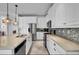 Elegant white kitchen featuring ample counter space, stainless steel appliances, and modern pendant lighting at 10640 Tibbett St, Orlando, FL 32832