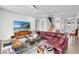 Spacious living room featuring a leather sofa, a TV, a modern coffee table, and a staircase in the background at 10640 Tibbett St, Orlando, FL 32832