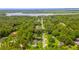 Scenic aerial view of a neighborhood surrounded by lush green trees and a calm lake at 109 Poinciana Ln, Deltona, FL 32738