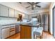 Well-lit kitchen with island seating, stainless steel dishwasher, and access to outdoor patio at 109 Poinciana Ln, Deltona, FL 32738