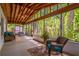 Relaxing screened porch with wood ceiling, comfortable seating, and a serene wooded view at 109 Poinciana Ln, Deltona, FL 32738