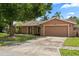 Single-story home with attached two-car garage, driveway, and mature shade tree at 119 Glendale Dr, Longwood, FL 32750
