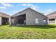 Backyard view with screen enclosed lanai offering additional outdoor living space on a sunny day at 1252 Ballyshannon Pkwy, Orlando, FL 32828