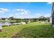 A serene view of the lush backyard overlooking a tranquil lake with a patio area at 1252 Ballyshannon Pkwy, Orlando, FL 32828