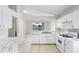 An open kitchen featuring white cabinetry and appliances and tile flooring with a view of the living space beyond at 1252 Ballyshannon Pkwy, Orlando, FL 32828