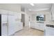 An open kitchen featuring white cabinetry and appliances and tile flooring with a view of the living space beyond at 1252 Ballyshannon Pkwy, Orlando, FL 32828