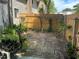 Overgrown backyard with brick pavers, enclosed by a wooden fence, and showing a house on the left at 1409 Oak Pl # F, Apopka, FL 32712