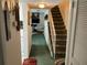 Hallway leading to staircase and living room with views of white couches and television at 1409 Oak Pl # F, Apopka, FL 32712