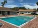 Community pool surrounded by lounge chairs, and red brick deck, perfect for relaxation and leisure at 1409 Oak Pl # F, Apopka, FL 32712