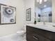 Bathroom with single vanity, stylish mirror and shower with glass doors at 1521 Tranquil Ave, Clermont, FL 34714