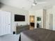 Stylish bedroom showcasing a television, ceiling fan, and an ensuite bathroom entrance at 1521 Tranquil Ave, Clermont, FL 34714