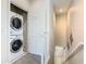 Convenient laundry area with stacked washer and dryer units near the stairs at 1521 Tranquil Ave, Clermont, FL 34714