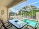 Private screened-in pool and patio area with dining set for relaxing by the pool at 1521 Tranquil Ave, Clermont, FL 34714