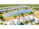 Beautiful aerial view of a residential community with a central lake and colorful homes at 1545 Fairview Cir, Reunion, FL 34747