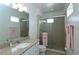 Bathroom featuring tiled shower with glass door, granite counters, and ample mirror space at 1545 Fairview Cir, Reunion, FL 34747