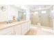 Bright bathroom featuring a dual sink vanity and glass enclosed shower at 1545 Fairview Cir, Reunion, FL 34747