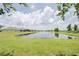 Lush green backyard view of a tranquil community pond at 1774 Pasture Loop, Oviedo, FL 32765