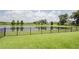 Spacious backyard featuring lush green grass, a black fence, and a peaceful pond at 1774 Pasture Loop, Oviedo, FL 32765