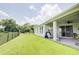 Expansive backyard with a well-maintained lawn, black iron fence, and a serene pond view at 1774 Pasture Loop, Oviedo, FL 32765