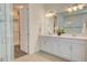White cabinets and double sinks brighten this bath with a view of the glass shower at 1774 Pasture Loop, Oviedo, FL 32765