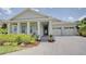 Charming home featuring a manicured lawn, brick paved driveway, and a welcoming front porch with classic columns at 1774 Pasture Loop, Oviedo, FL 32765