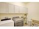 Laundry room with front load washer and dryer, a stainless sink, and storage cabinets at 1774 Pasture Loop, Oviedo, FL 32765