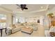 Spacious living room with decorative pillows, woven ottoman, and bright neutral tones at 1774 Pasture Loop, Oviedo, FL 32765
