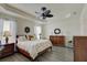 Bright main bedroom features a decorative ceiling fan, tray ceiling, and light gray flooring at 1774 Pasture Loop, Oviedo, FL 32765