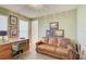 Inviting home office with vintage desk, comfortable leather sofa, and light green walls at 1774 Pasture Loop, Oviedo, FL 32765