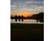 Scenic pond view at sunrise, reflecting a colorful sky and trees at 1774 Pasture Loop, Oviedo, FL 32765