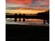 Stunning view of a fiery sunset reflected on a tranquil pond at 1774 Pasture Loop, Oviedo, FL 32765