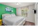 Bedroom showcasing a queen bed, a green accent wall, and a window at 1909 Majorca Dr, Kissimmee, FL 34747