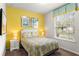 Bright bedroom featuring a yellow accent wall, queen bed, and a window with blinds at 1909 Majorca Dr, Kissimmee, FL 34747