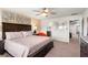 Bedroom with a dark wood bed, patterned linens, bedside table, fan, and accent wall at 1909 Majorca Dr, Kissimmee, FL 34747