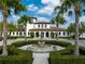 Beautiful clubhouse entrance with a fountain and lush landscaping in a tropical community at 1909 Majorca Dr, Kissimmee, FL 34747