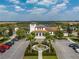 Community building with a parking lot, fountain, palm trees, and manicured landscaping at 1909 Majorca Dr, Kissimmee, FL 34747