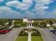 Community building with a parking lot, fountain, palm trees, and manicured landscaping at 1909 Majorca Dr, Kissimmee, FL 34747