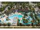 Aerial view of a community pool with a lazy river, water slides, lounge seating, and well-maintained landscaping at 1909 Majorca Dr, Kissimmee, FL 34747