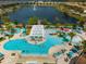 Aerial view of community pool with lazy river, lounge seating, water playground and pier with a view of the lake at 1909 Majorca Dr, Kissimmee, FL 34747