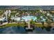 Aerial view of a community pool, with a lazy river, water slides, lounge seating, and lakeside pier at 1909 Majorca Dr, Kissimmee, FL 34747
