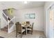 Cozy dining area with a round table, four chairs, and stairs in the background at 1909 Majorca Dr, Kissimmee, FL 34747